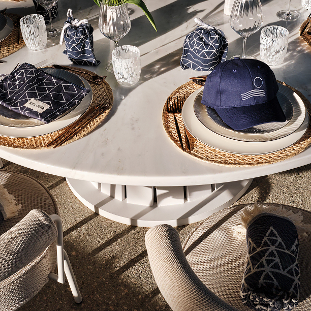 Elegant white table setting with blue gifts, hats, and pouches for guests, perfect for social events.