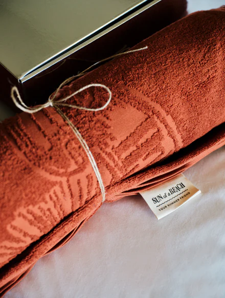 Rolled luxury towel included in a curated Sun of a Beach welcome gift, perfect for enhancing the guest experience.